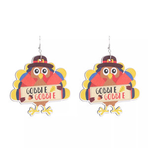 Playful Thanksgiving turkey dangle earrings with brown hats and "Gobble Gobble" signs.