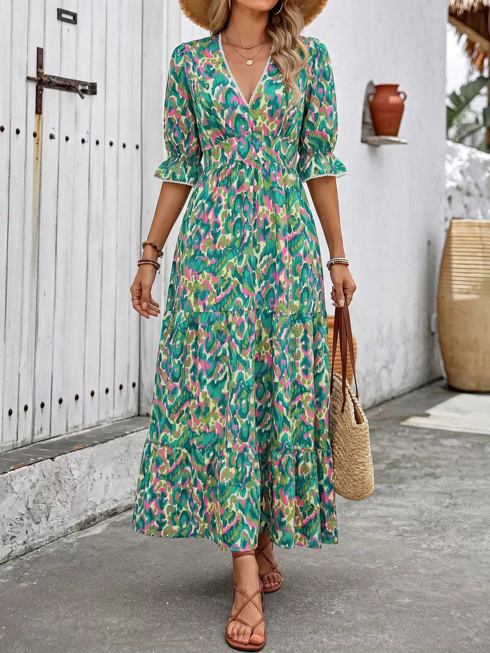 Vibrant V-neck flounce sleeve maxi dress in abstract print with tiered skirt and lace trim.