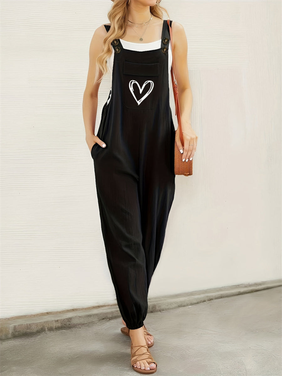 Black cotton overalls jumpsuit with white heart pocket detail, wide leg, and adjustable straps.