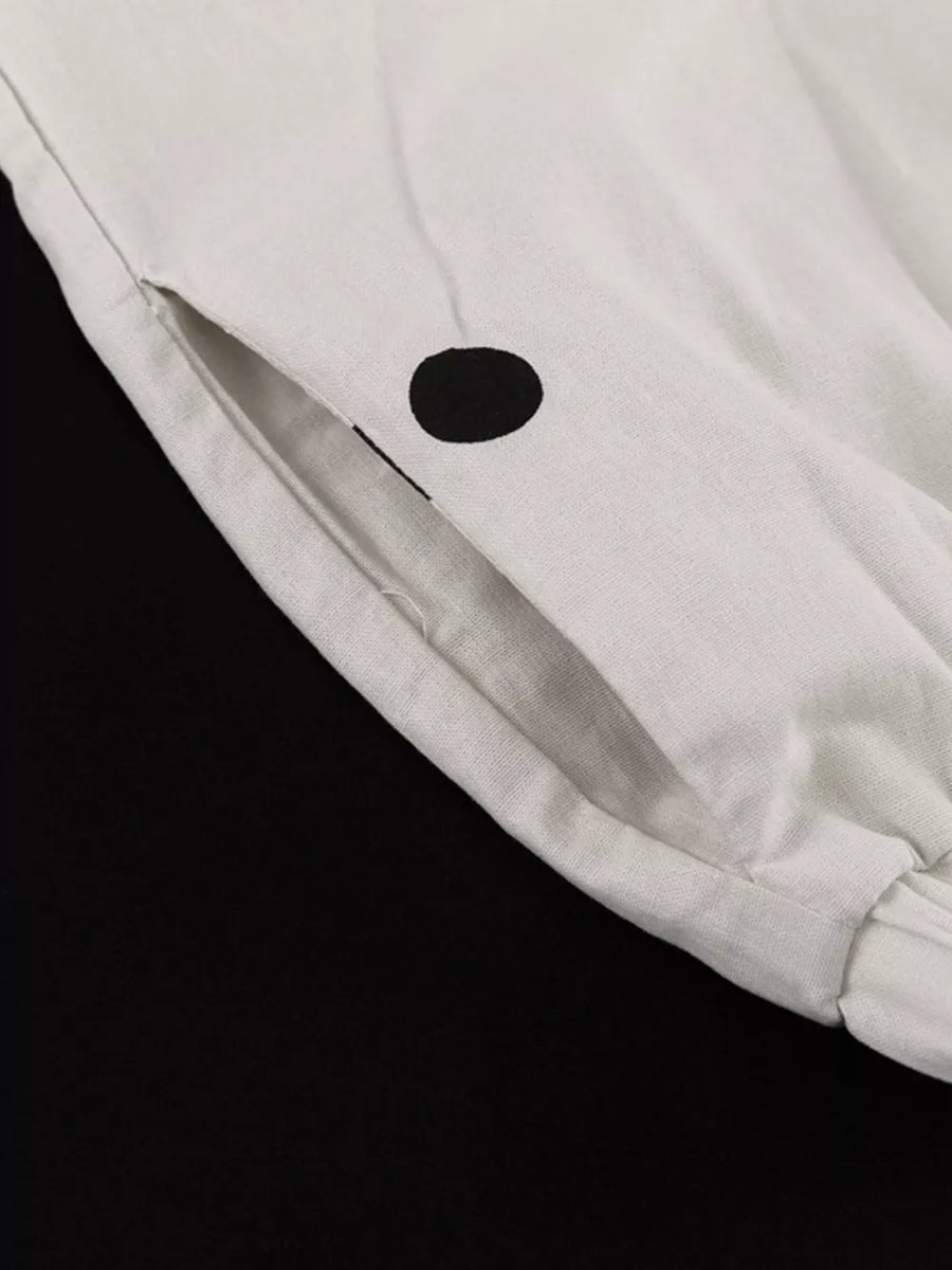 White linen pants with black polka dots and a side pocket.