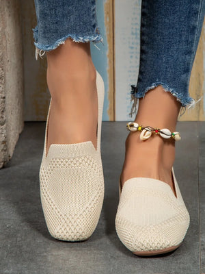 Beige knit ballet flats with a diamond pattern detail.