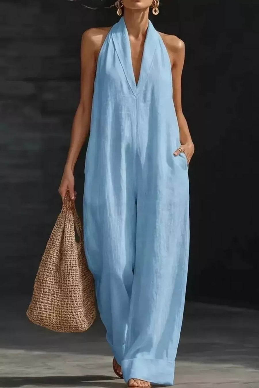 Light blue halter neck pocketed jumpsuit with wide legs and a deep V-neck.