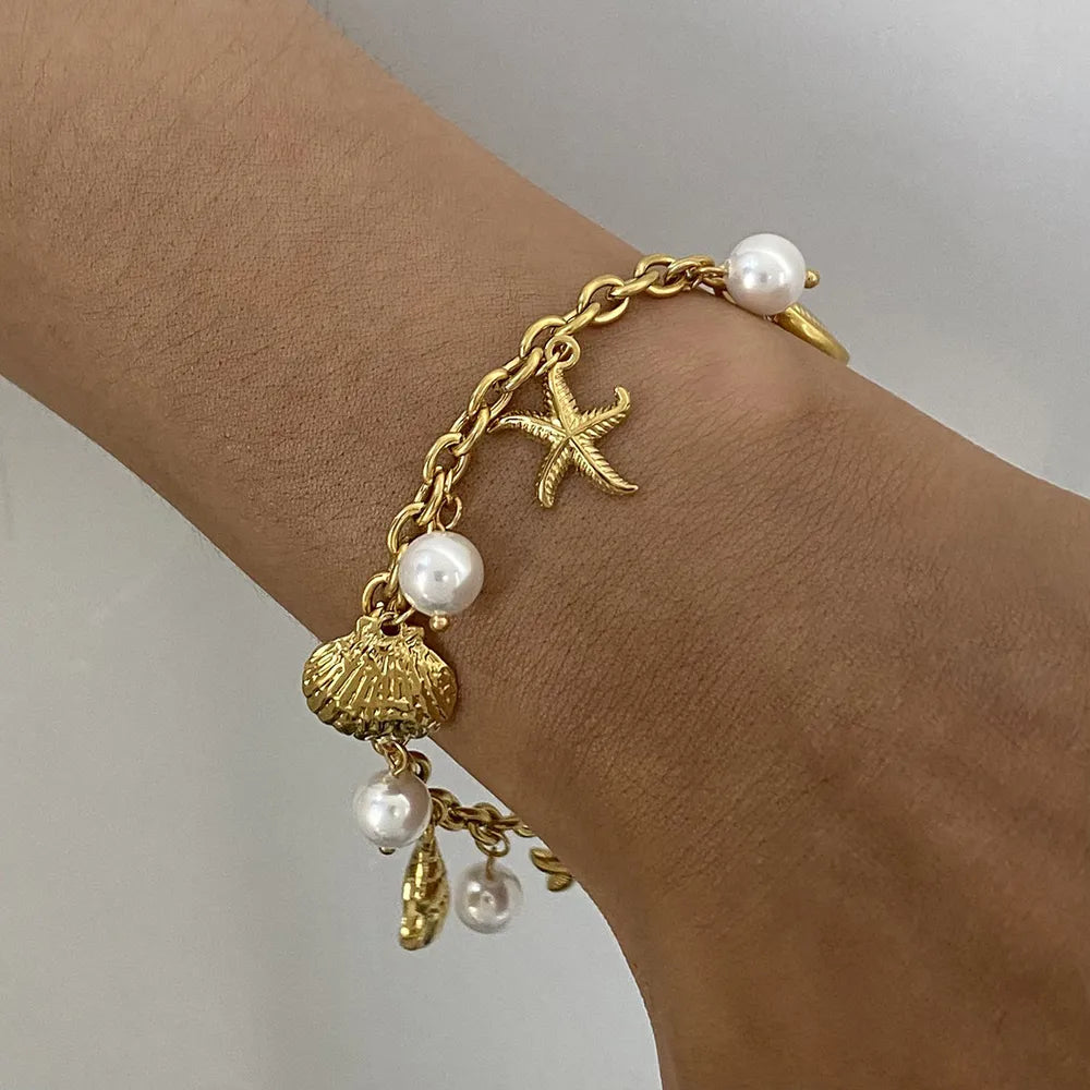 bracelet in gold featuring seashell pendants and straight fit