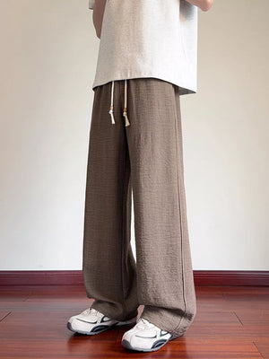 Brown wide-leg drawstring sweatpants with a relaxed fit and textured fabric.