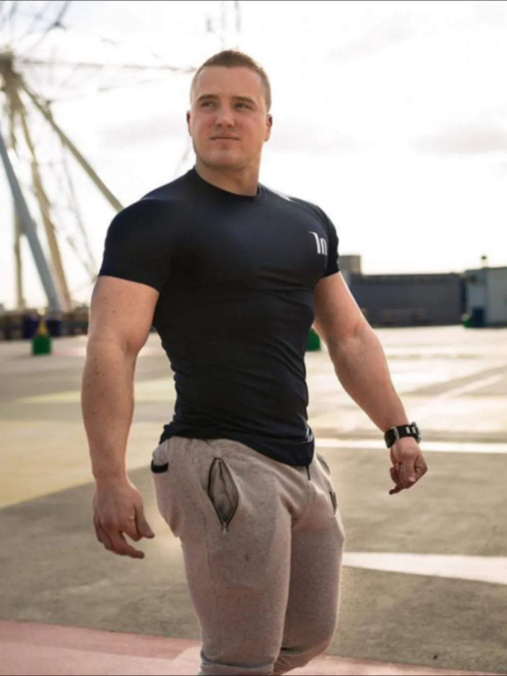 Black performance fit raglan tee with white logo detail and short sleeves.