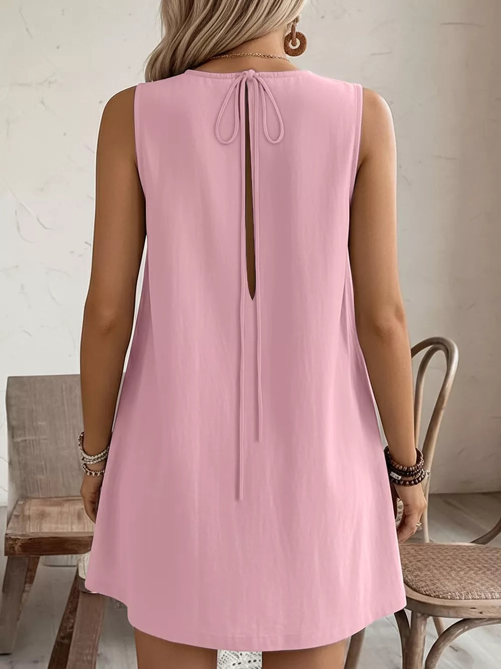 Blush pink sleeveless dress with back tie detail and open back.
