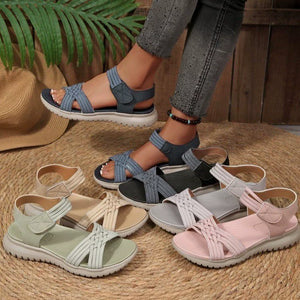 Woven strap open-toe flat sandals in beige, black, pink, green, blue, and gray with adjustable straps.