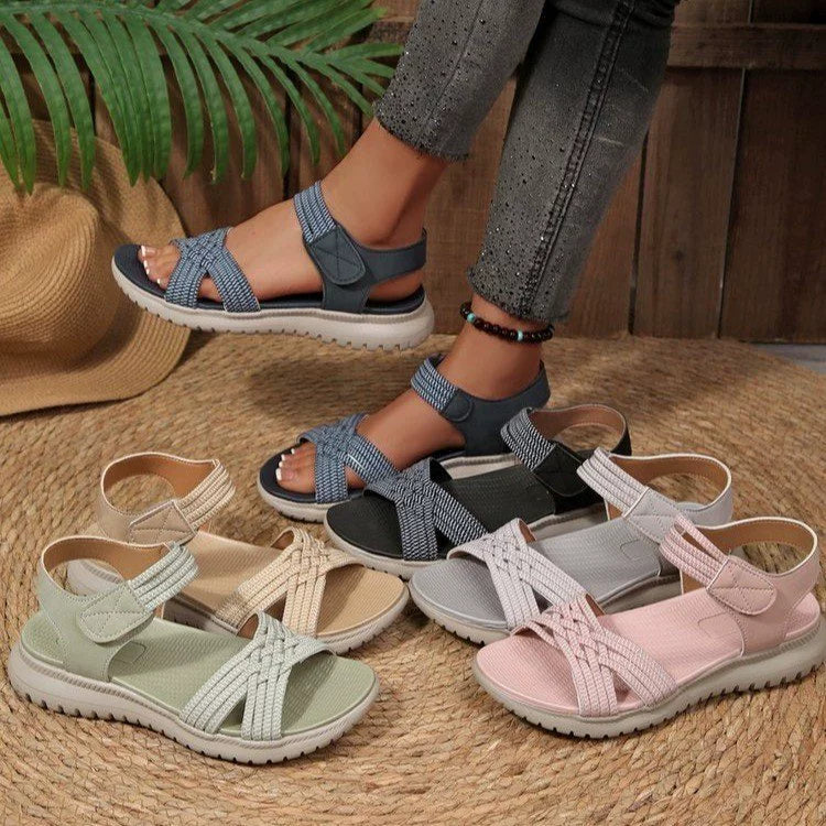 Woven strap open-toe flat sandals in beige, black, pink, green, blue, and gray with adjustable straps.