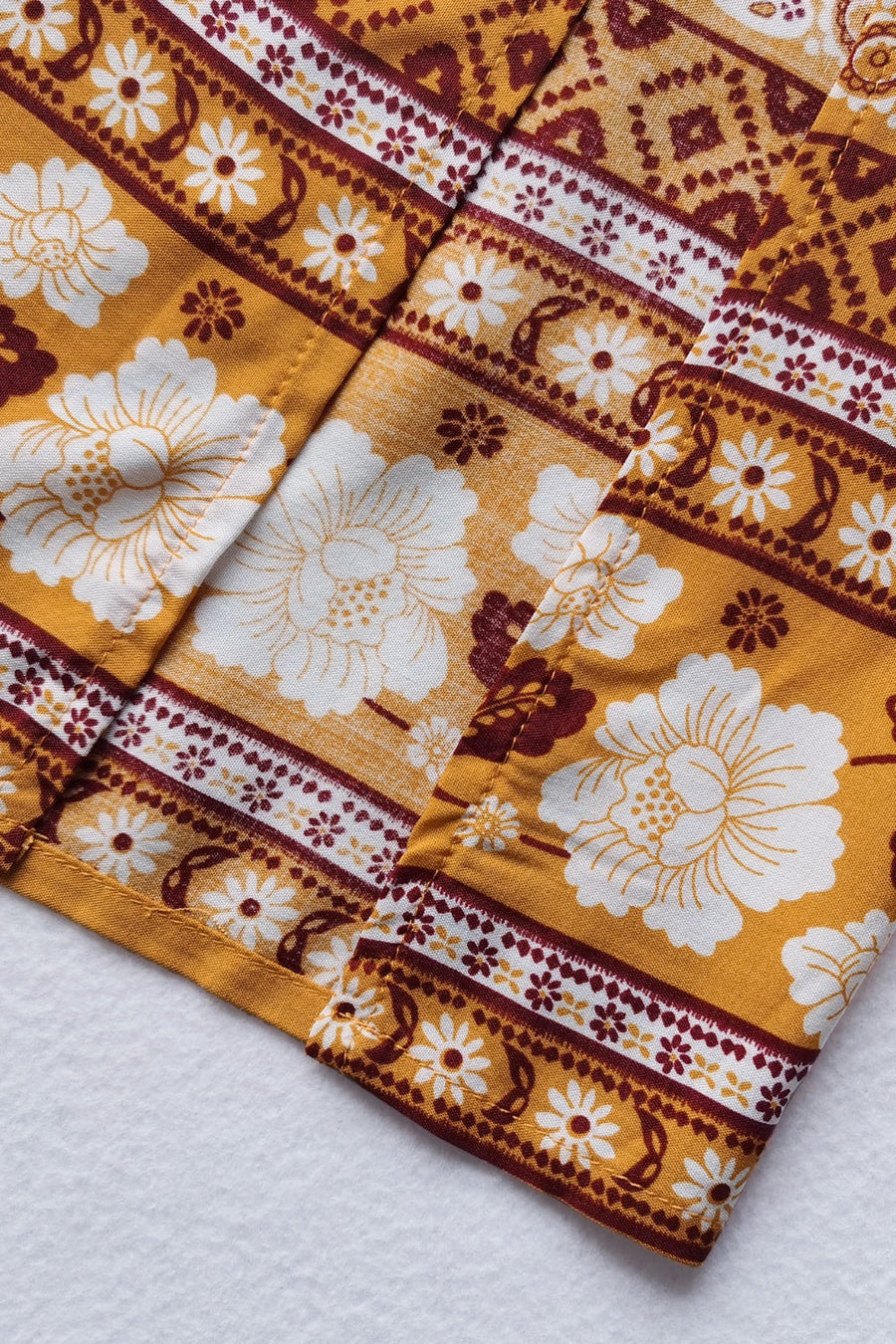 Bohemian floral print crop top and maxi skirt set in viscose, featuring a yellow base with white and maroon floral patterns.