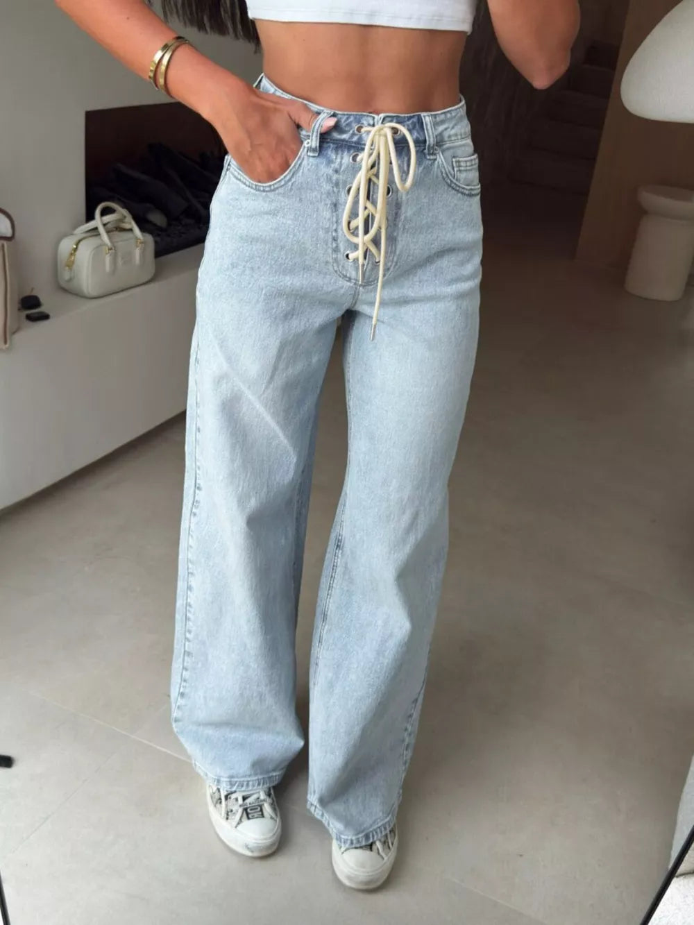 Light wash denim wide leg jeans with lace-up front detail.