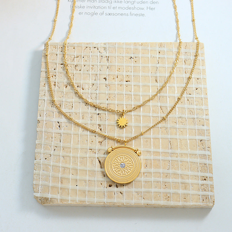 Gold layered necklace with celestial medallion and sun charm