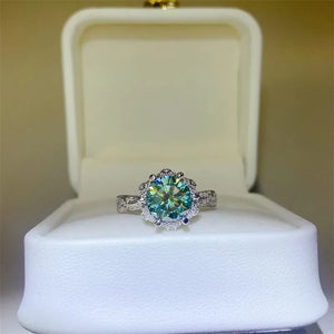 Sterling silver solitaire ring with a green moissanite center stone and a diamond halo.