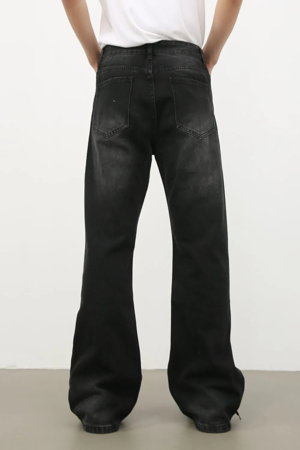 Dark wash denim trousers with exaggerated flare legs and a 70s style.