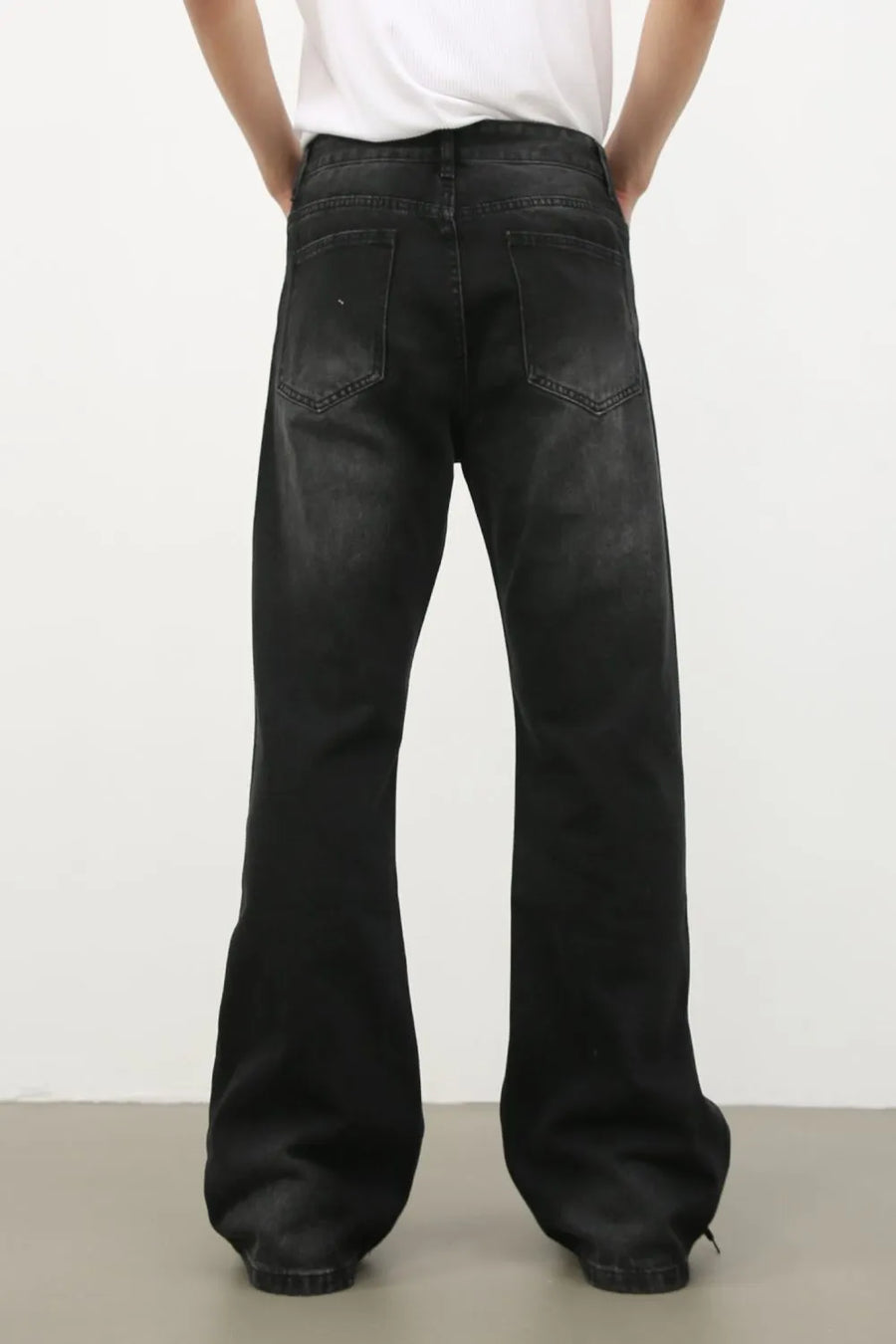 Dark wash denim trousers with exaggerated flare legs and a 70s style.