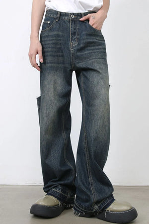 Baggy dark navy denim jeans with knee slits and distressed details.