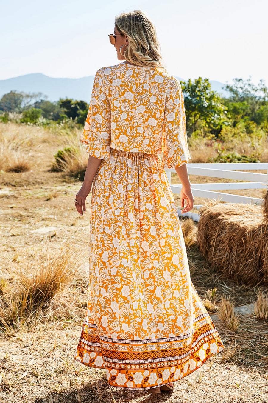 Bohemian floral crop top and maxi skirt set in tangerine viscose with flutter sleeves and tiered hem.