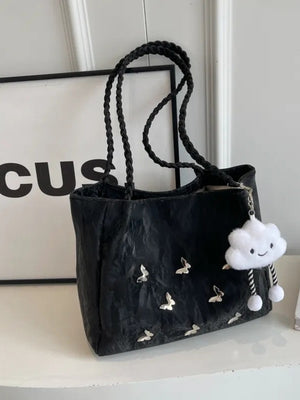 Black shopper bag with braided handles, butterfly details, and cloud charm