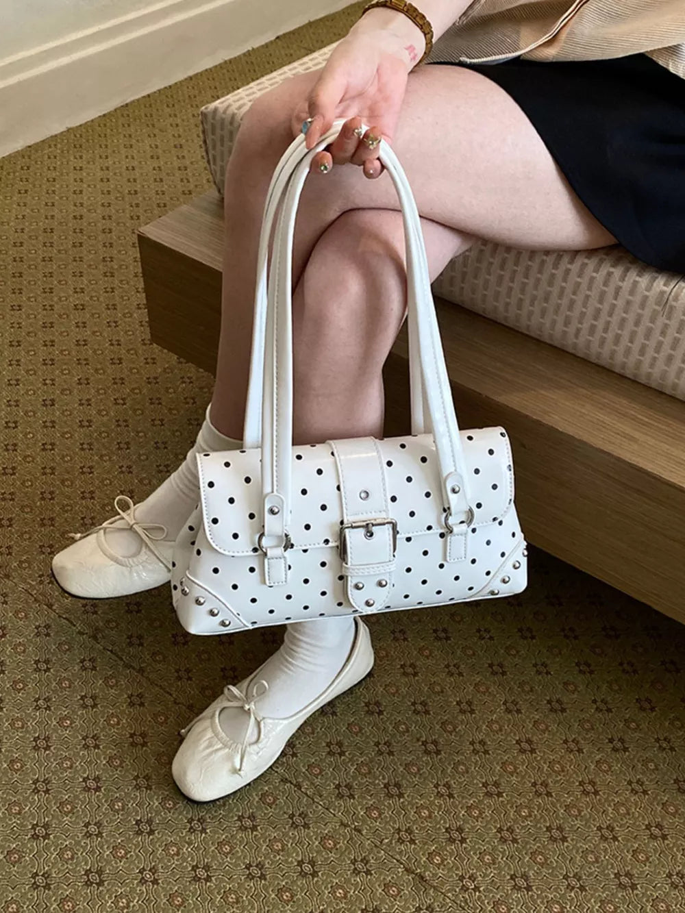 White handbag featuring studded and polka-dot