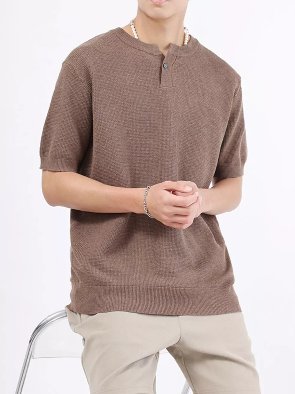 Men's brown knit henley shirt with short sleeves and button placket.