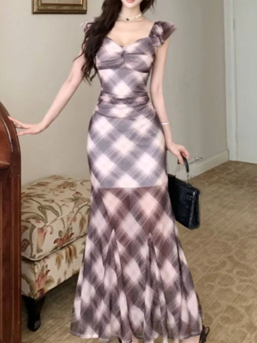 Ruched plaid bodycon maxi dress with sweetheart neckline and ruffled cap sleeves in blue and brown.