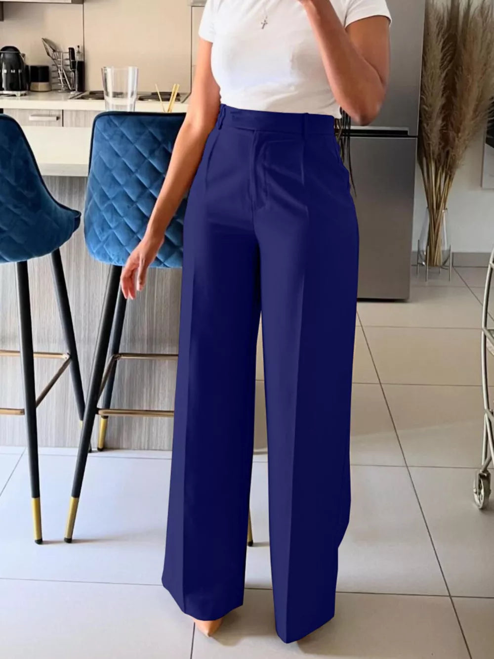 Dark blue high-waisted wide-leg trousers with a relaxed fit, styled with a white top.