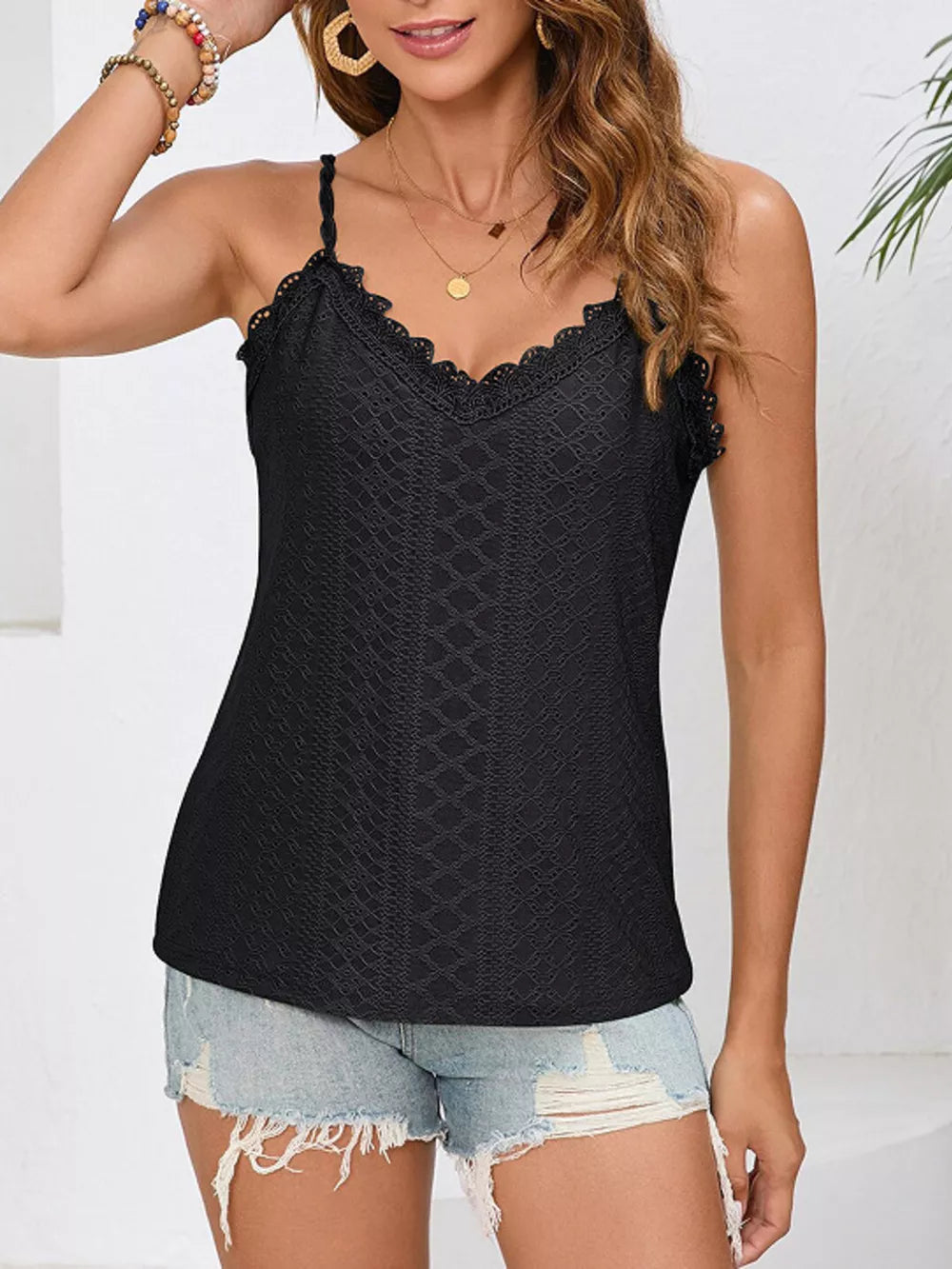 Black lace camisole with V-neck and delicate lace trim, textured pattern.