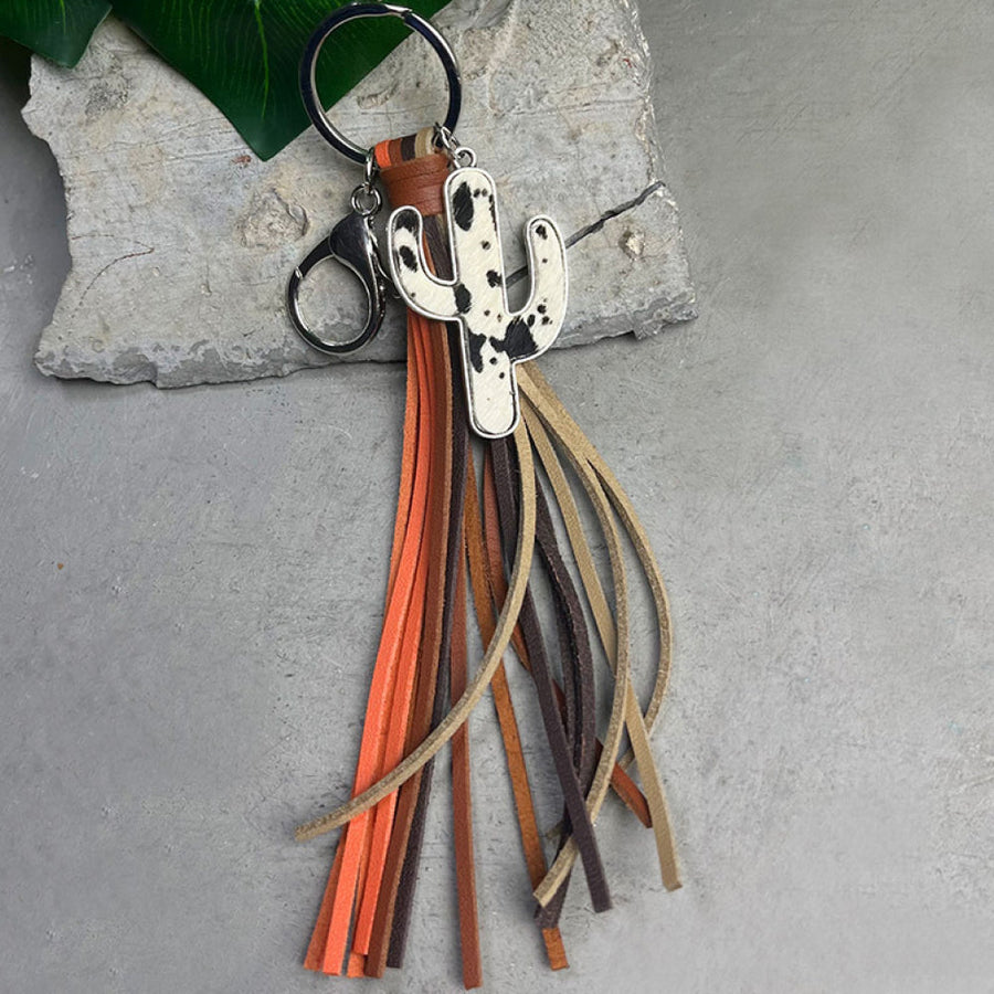 Leather cactus keyring with cow print detail and multi-colored tassels.