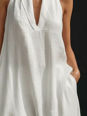 White halter neck maxi dress in cotton linen with pockets and V-neckline.