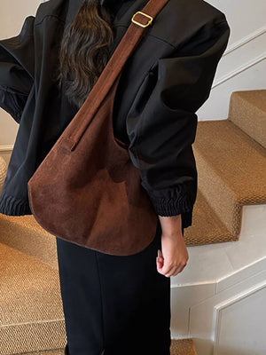 Large brown suede hobo shoulder bag with gold buckle detail and adjustable strap.