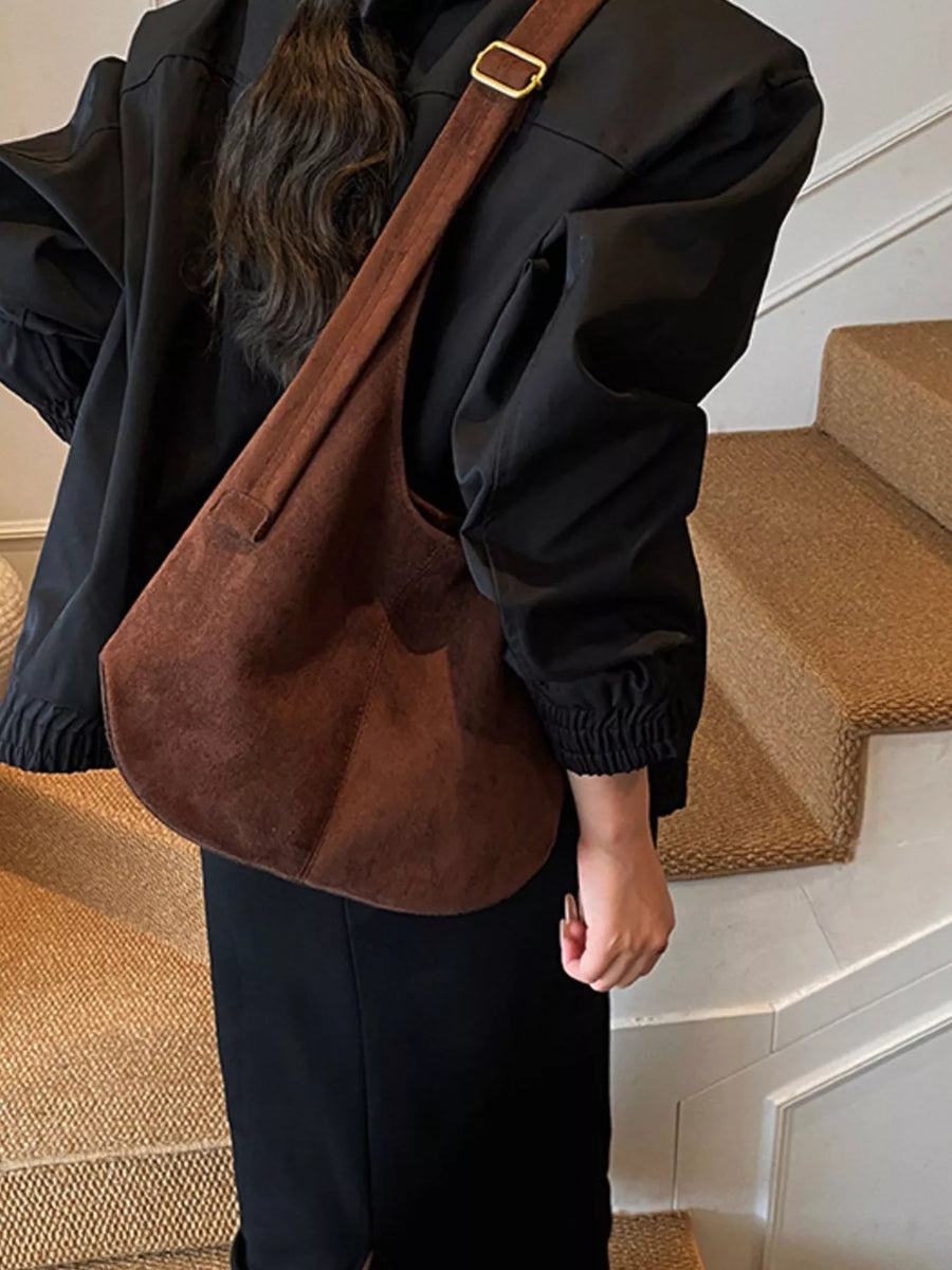 Large brown suede hobo shoulder bag with gold buckle detail and adjustable strap.