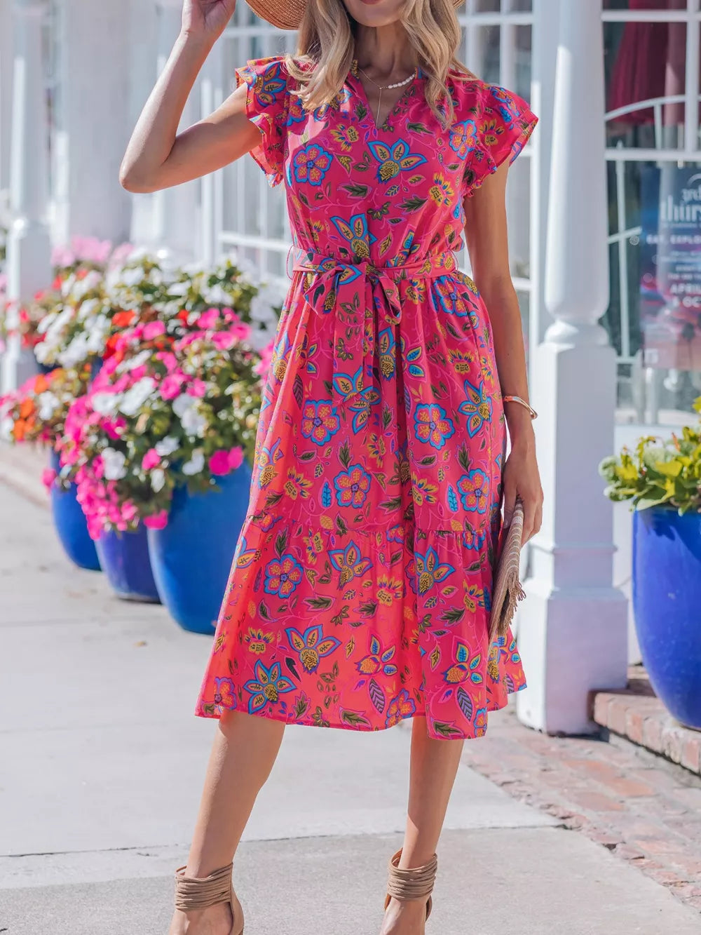 Floral midi dress with ruffled sleeves, belted waist, and tiered skirt in a cotton blend.