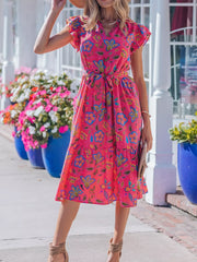 Floral midi dress with ruffled sleeves, belted waist, and tiered skirt in a cotton blend.
