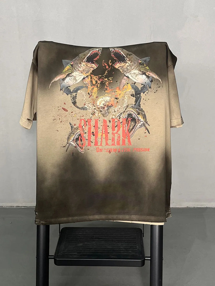 Khaki distressed t-shirt with a bold shark graphic and distressed details.