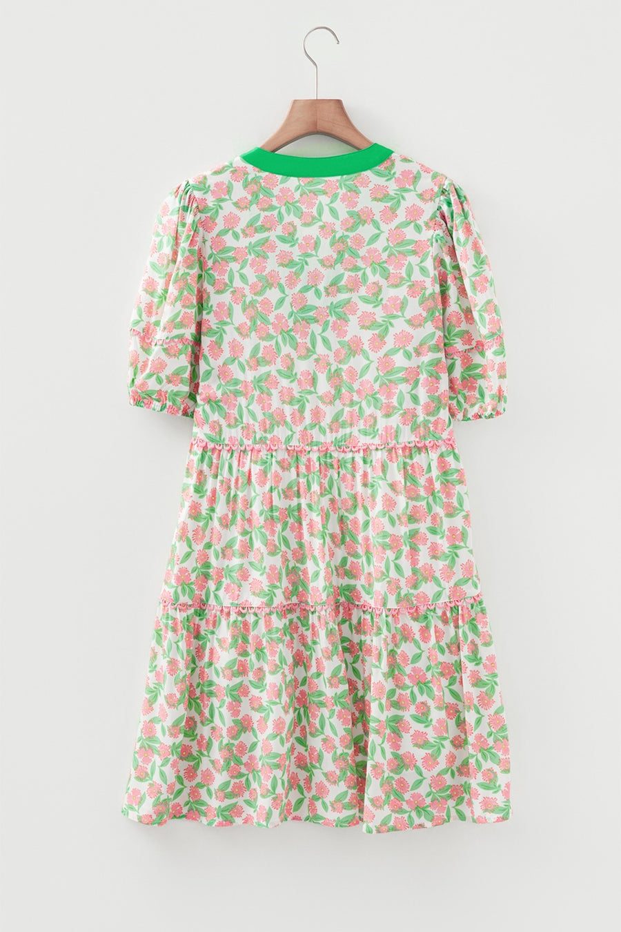 Women's tiered mini dress with puff sleeves, green neckline, and pink floral print.