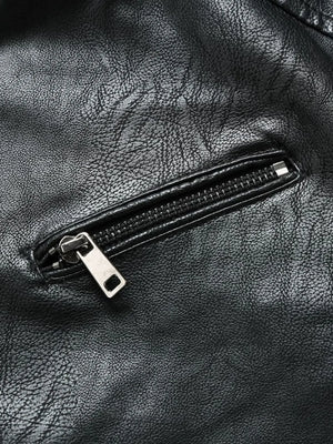 Black moto jacket detail showing a zippered pocket with silver hardware on faux leather.