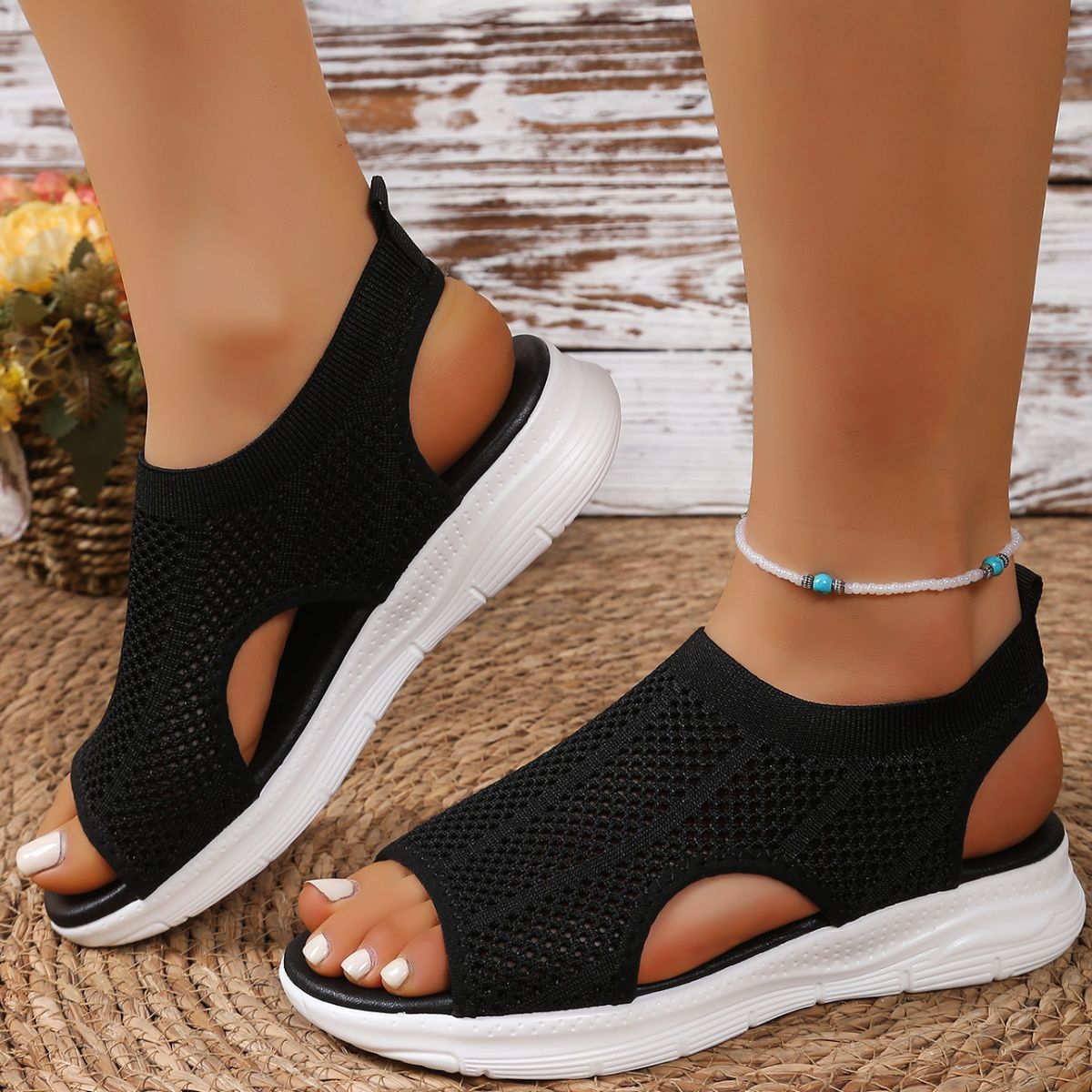 Black mesh open-toe sandals with a chunky white sole and ankle strap.