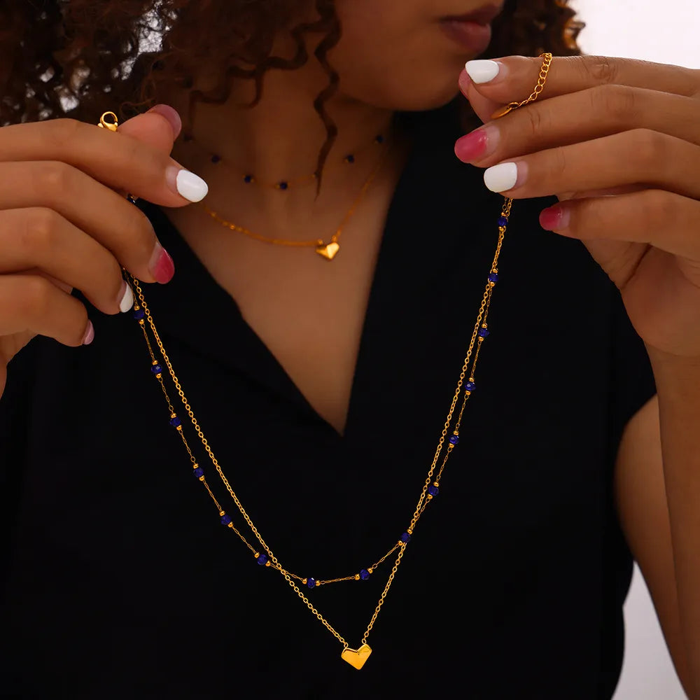 Gold layered necklace with blue beads and heart pendants