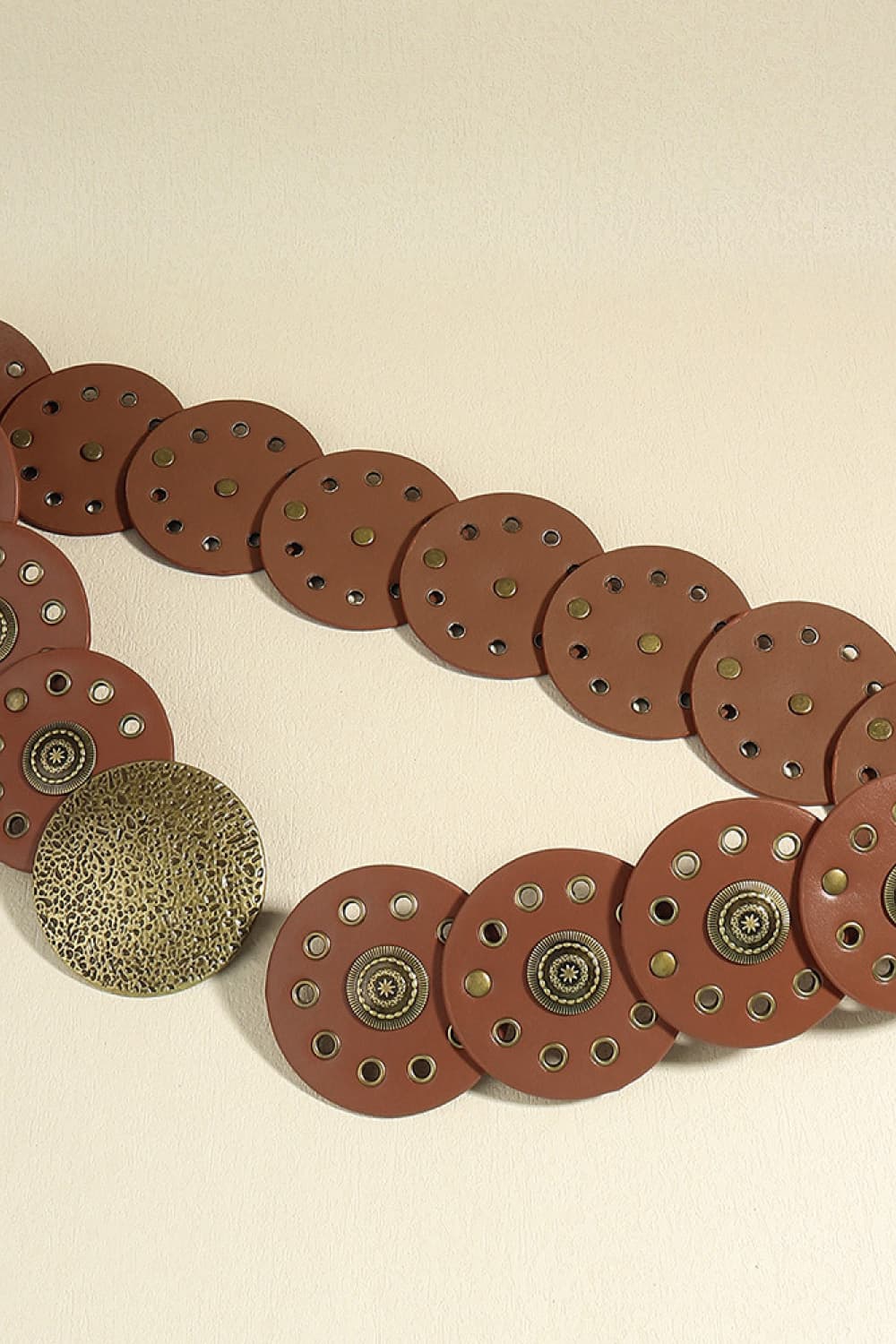 Brown faux leather belt with round disc embellishments and metal studs