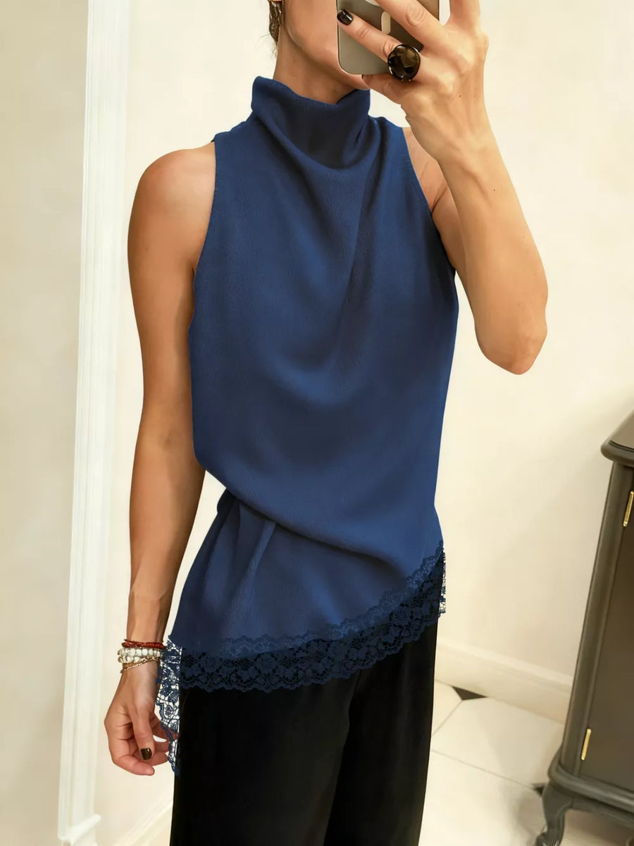 Dark blue asymmetrical cami top with lace trim and mock neck.