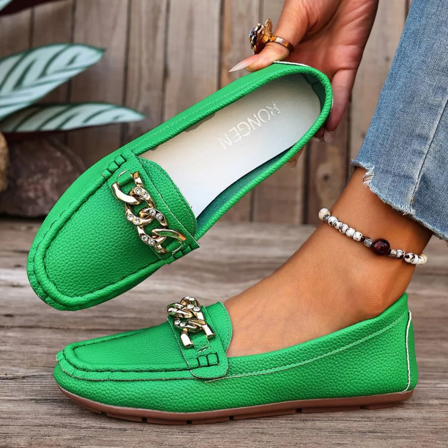 Green round-toe loafers with gold chain detail and textured leather.