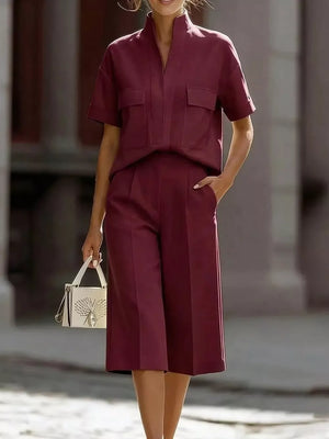 Burgundy two-piece set with pocketed shirt and culottes, styled with a white handbag.