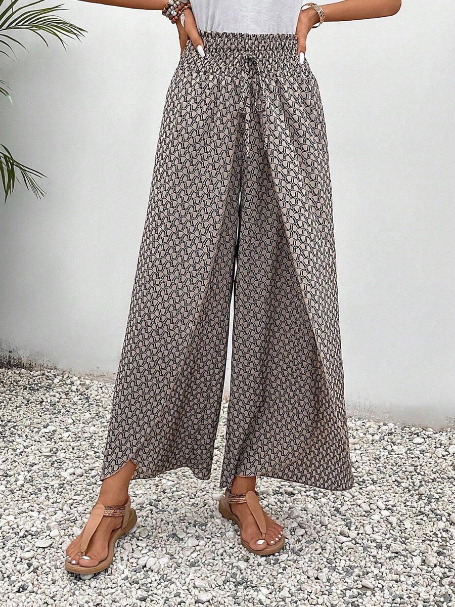 Palazzo pants with a geometric print and drawstring waist, styled with sandals.