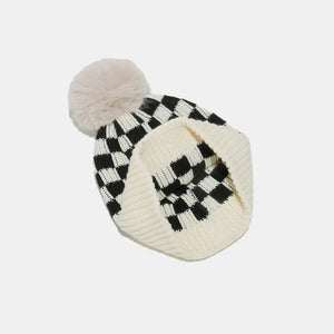 Checkerboard knit beanie in ivory and black with a faux fur pom.