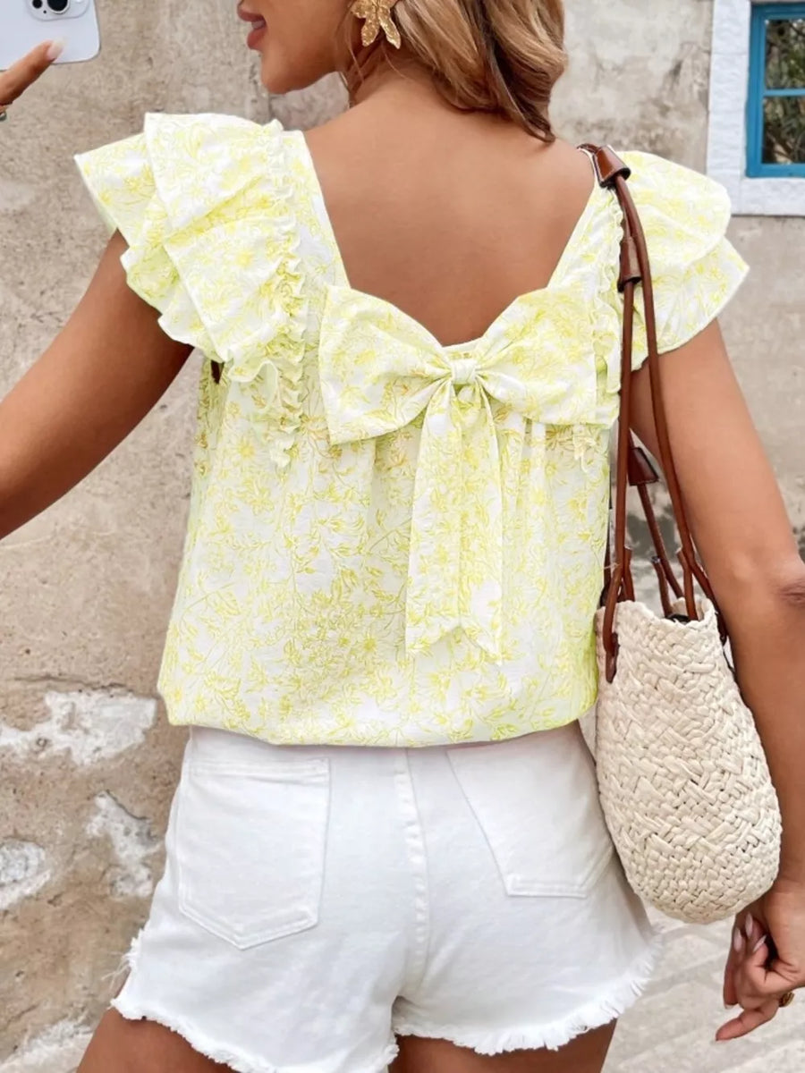 Yellow floral ruffle blouse with back bow detail and square neckline.
