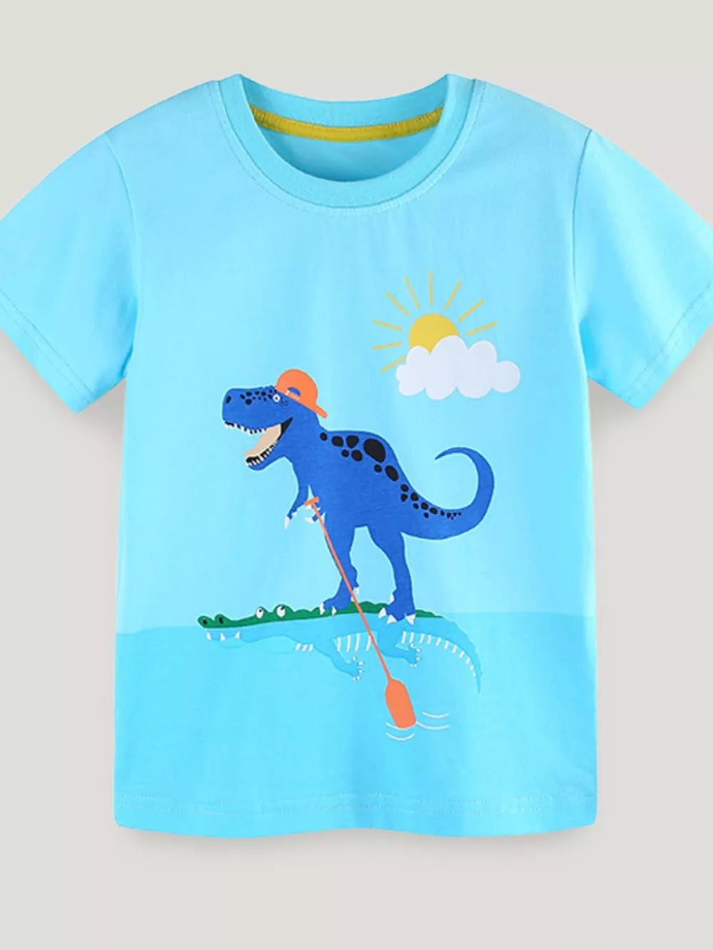 Blue toddler t-shirt with a graphic of a blue dinosaur wearing an orange cap and fishing in water with a crocodile.