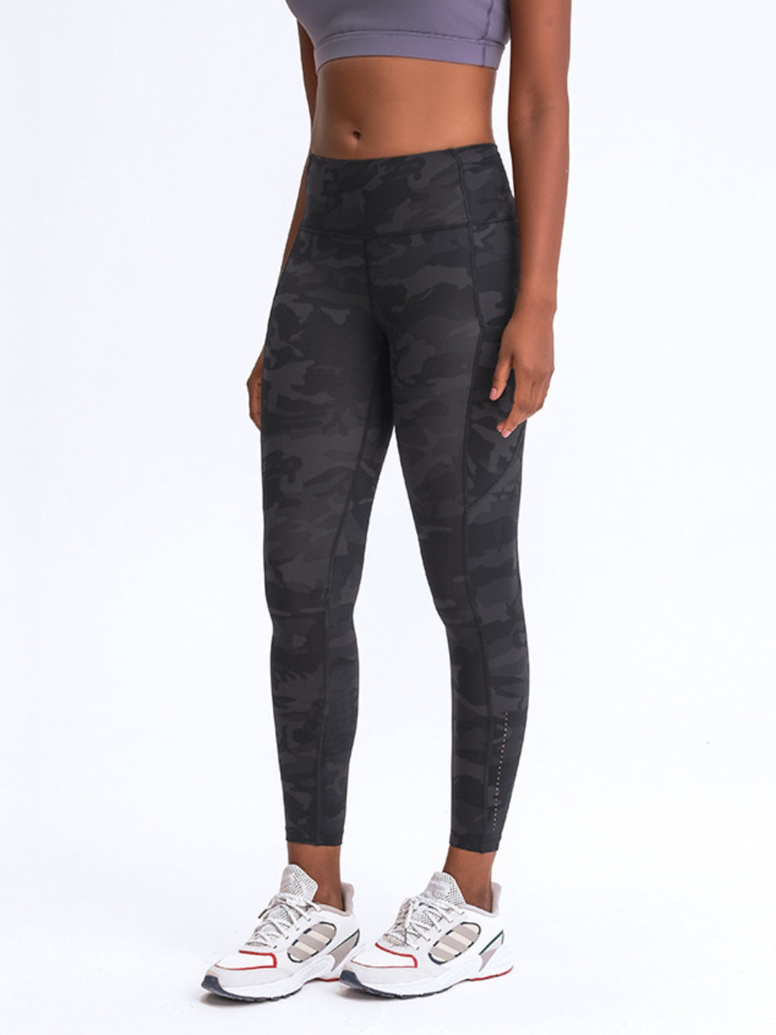 Green camouflage performance leggings with pockets and reflective detail.