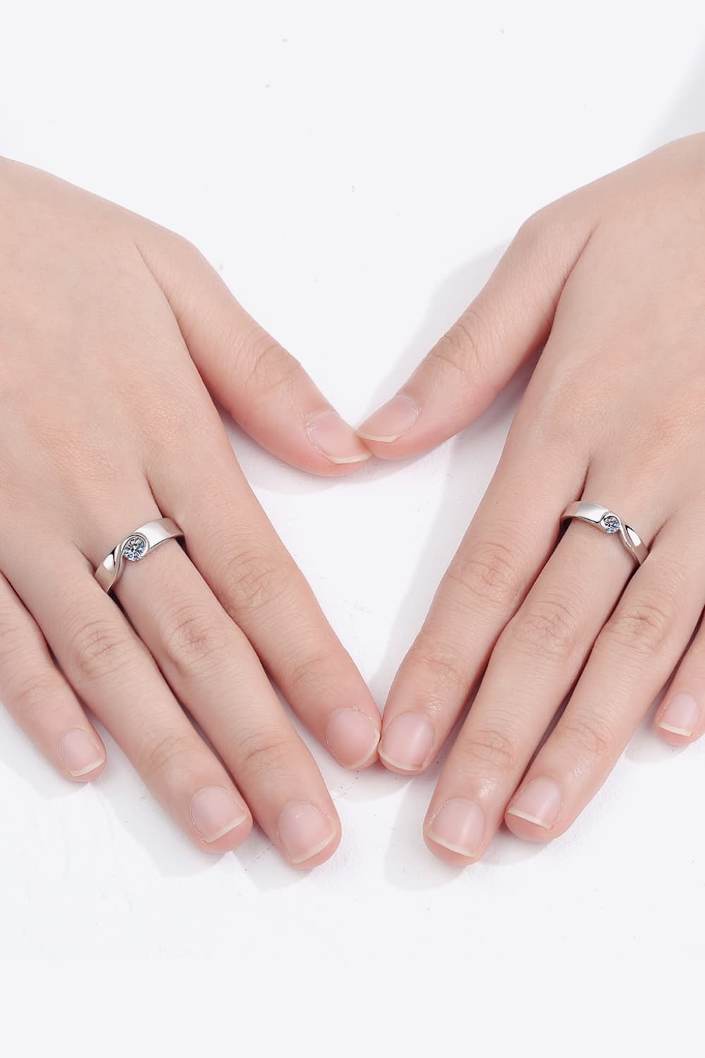 Curved Embrace diamond ring set for men and women, silver band with a single sparkling stone.