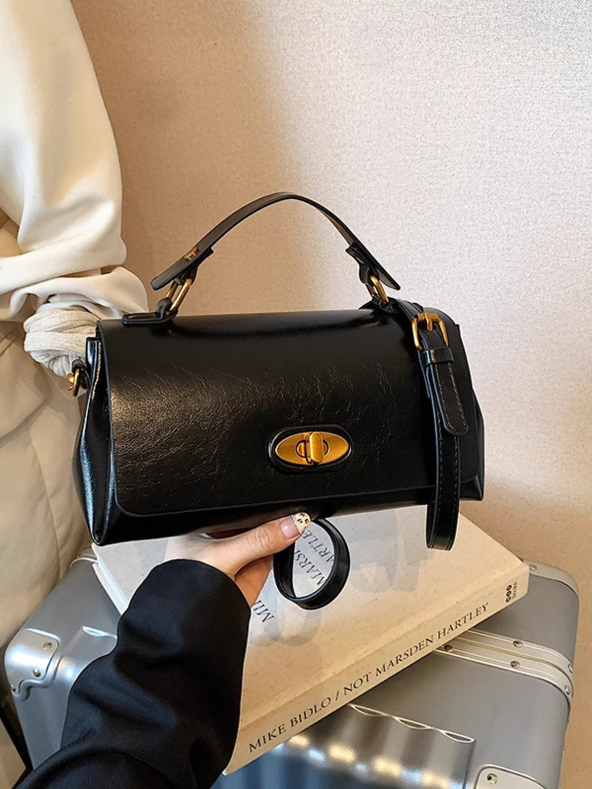 Black pu leather flap shoulder bag with gold hardware and top handle.