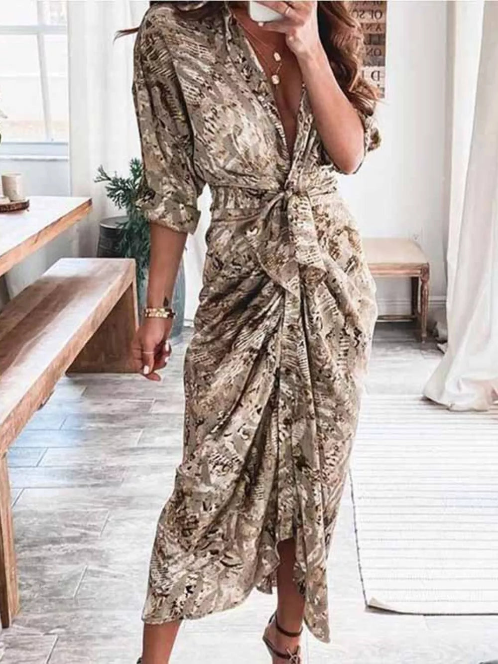 Elegant tie-waist midi dress in a tan and brown abstract print with a deep V-neck and ruched skirt.