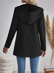 Black hooded zip jacket with textured cable-knit sleeves and hood detail.